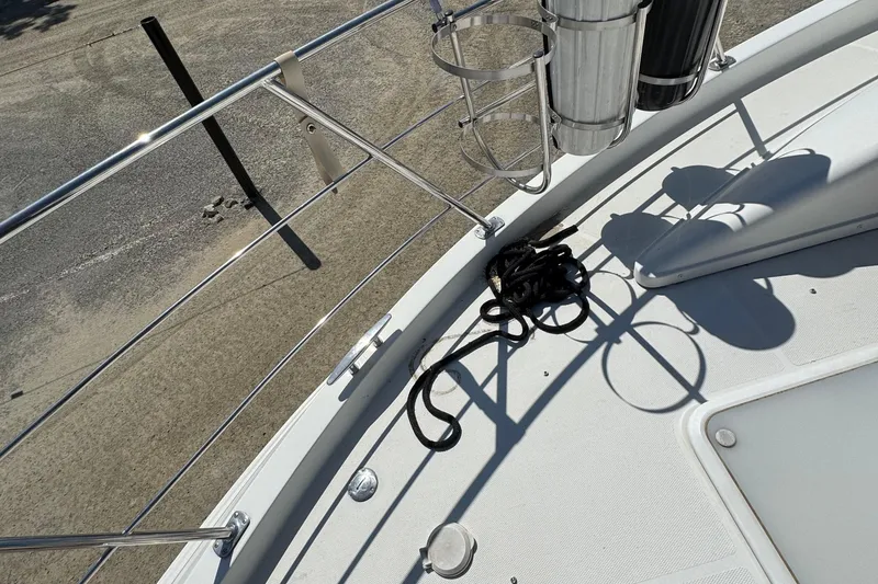 Slide: The Image of 2004 Carver 360 Mariner deck with railing, rope, and cup holders in sunlight. - 33