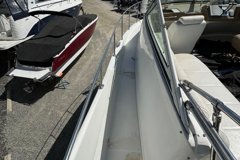 Slide: The Image of 2004 Carver 360 Mariner yacht docked beside covered boat, showcasing deck and seating area. - 34