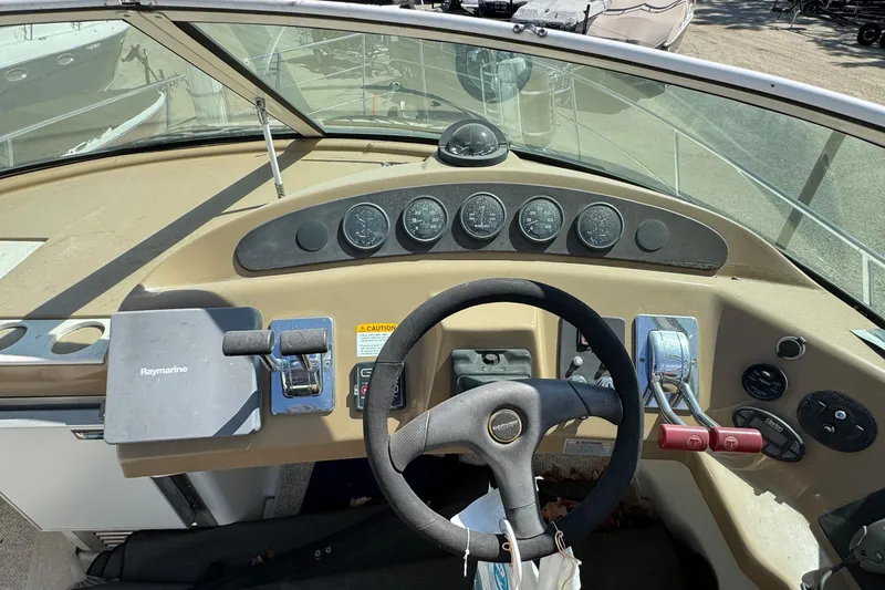 Slide: The Image of 2004 Carver 360 Mariner helm with steering wheel, gauges, and Raymarine navigation system. - 35