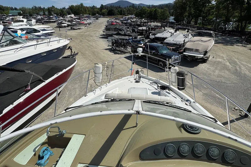 Slide: The Image of 2004 Carver 360 Mariner yacht in a busy marina with parked boats and vehicles. - 39
