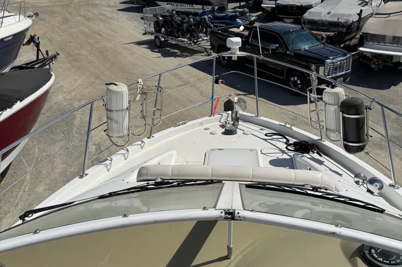 Slide: The Image of 2004 Carver 360 Mariner yacht docked, surrounded by vehicles and other boats. - 40