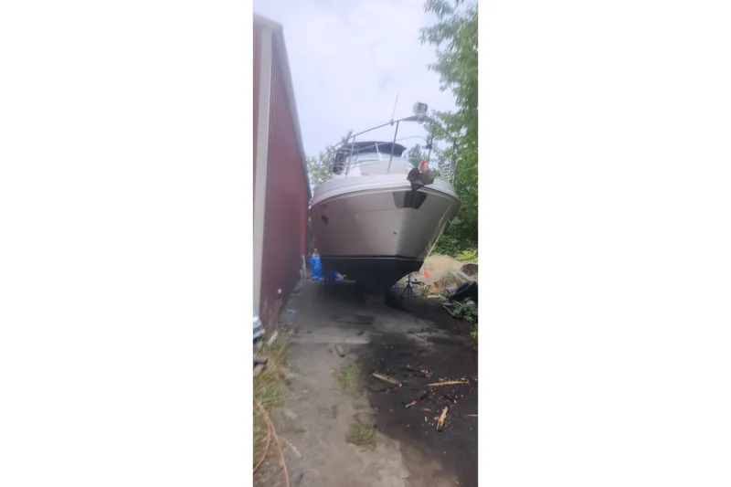 Slide: The Image of 2004 Carver 360 Mariner yacht on land, surrounded by trees and a building. - 46