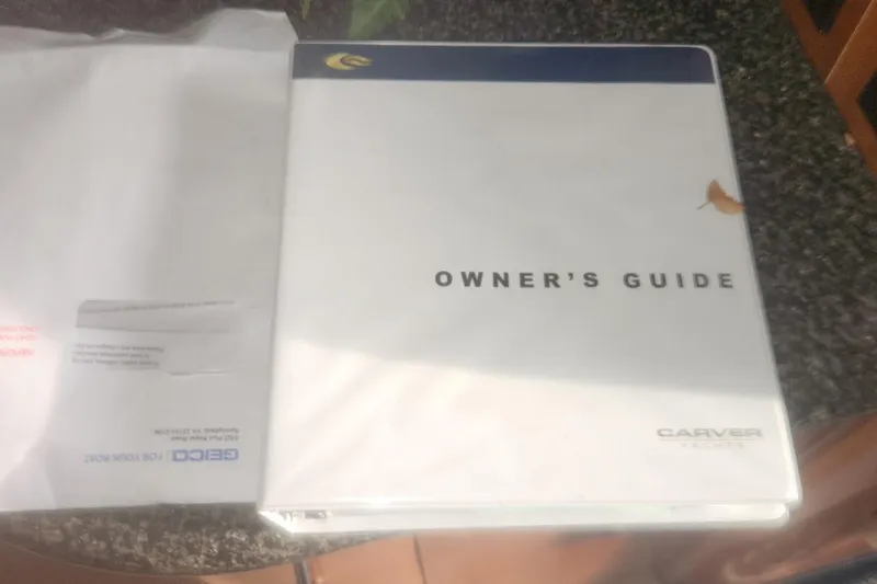 Slide: The Image of Owner's guide for 2004 Carver 360 Mariner yacht on a table. - 48