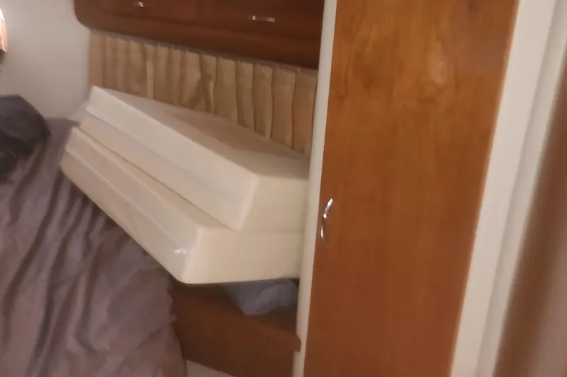 Slide: The Image of Interior of 2004 Carver 360 Mariner with stacked cushions and wooden cabinetry. - 50