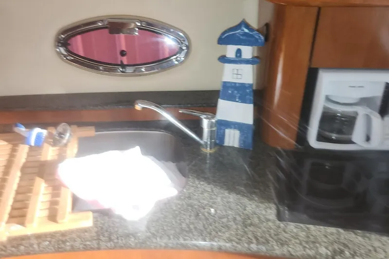 Slide: The Image of 2004 Carver 360 Mariner kitchen with sink, coffee maker, and lighthouse decor. - 53