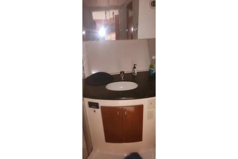 Slide: The Image of 2004 Carver 360 Mariner bathroom with sink, mirror, and wooden cabinet. - 54