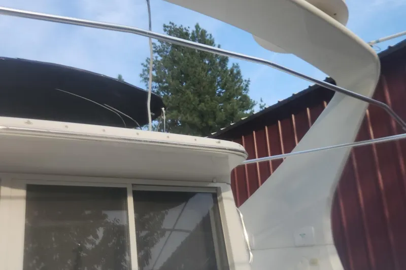 Slide: The Image of 2004 Carver 360 Mariner yacht with railing and canopy, docked near a red building. - 61