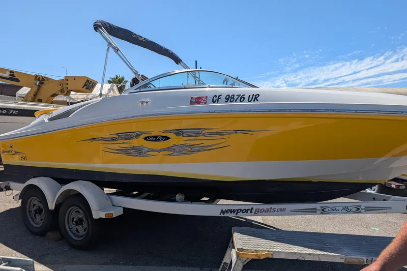 Slide: The Image of 2007 Sea Ray 195 Sport boat in yellow on trailer, sunny day background. - 2