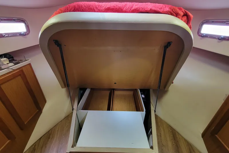 Slide: The Image of 2006 Mainship 40 Trawler interior with under-bed storage compartment open. - 100