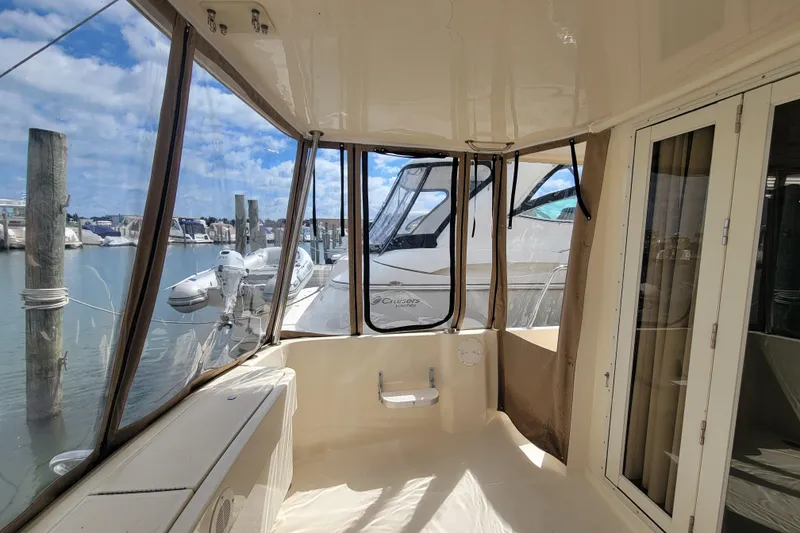 Slide: The Image of 2006 Mainship 40 Trawler interior with marina view, featuring spacious seating and clear windows. - 102