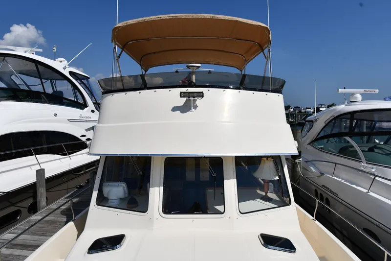 Slide: The Image of 2006 Mainship 40 Trawler docked between two boats under a clear blue sky. - 11