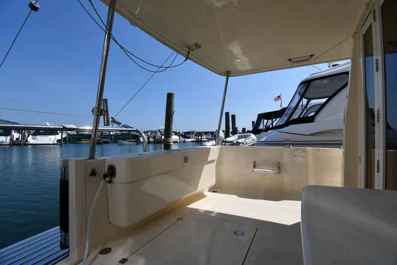 Slide: The Image of 2006 Mainship 40 Trawler docked at marina, featuring spacious deck and clear blue sky. - 15