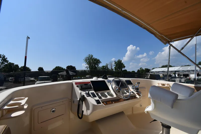 Slide: The Image of 2006 Mainship 40 Trawler helm with steering wheel, controls, and seating under a canopy. - 21