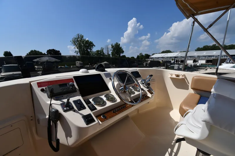 Slide: The Image of 2006 Mainship 40 Trawler helm with steering wheel, controls, and seating under clear blue sky. - 22
