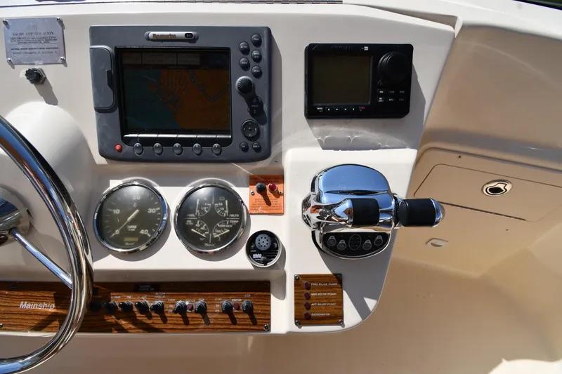 Slide: The Image of Control panel of a 2006 Mainship 40 Trawler with navigation and throttle controls. - 24