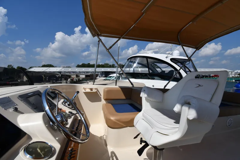 Slide: The Image of 2006 Mainship 40 Trawler helm with steering wheel and captain's chair under canopy. - 26