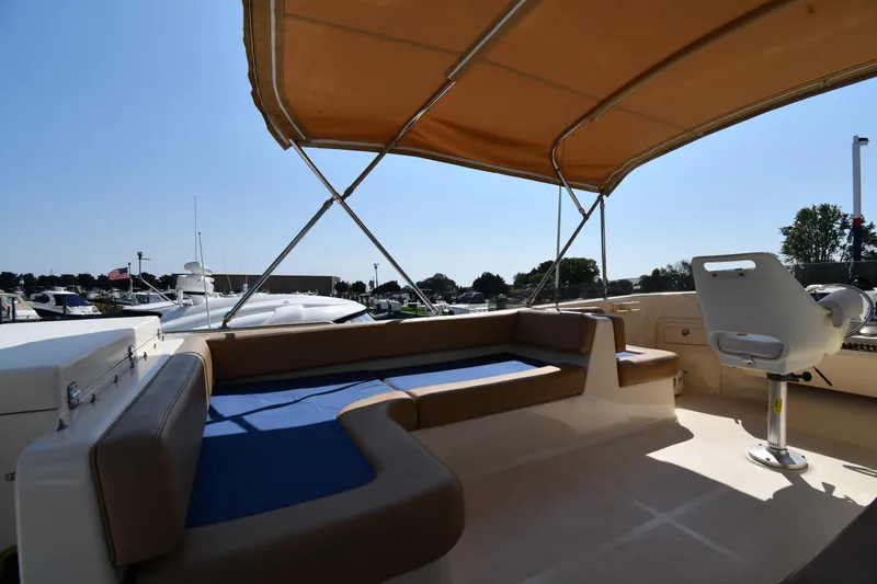 Slide: The Image of 2006 Mainship 40 Trawler with shaded seating area and helm, docked under clear sky. - 28