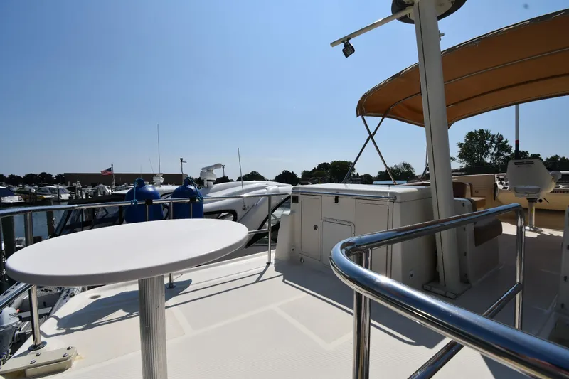 Slide: The Image of 2006 Mainship 40 Trawler deck with table, railing, and canopy in marina setting. - 32