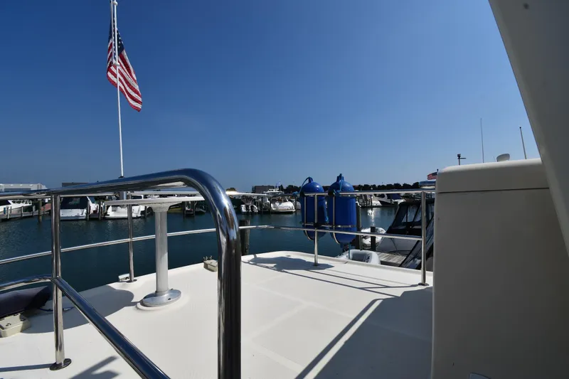 Slide: The Image of 2006 Mainship 40 Trawler deck with American flag, docked at marina under clear blue sky. - 35