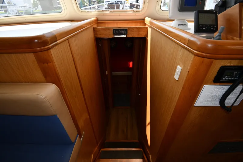 Slide: The Image of Interior view of 2006 Mainship 40 Trawler, featuring wooden stairs and navigation equipment. - 37