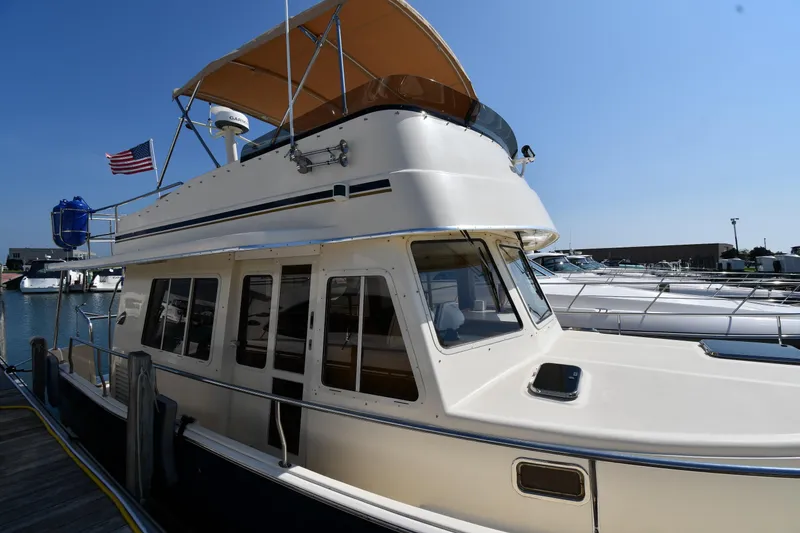 Slide: The Image of 2006 Mainship 40 Trawler docked at marina under clear blue sky. - 4