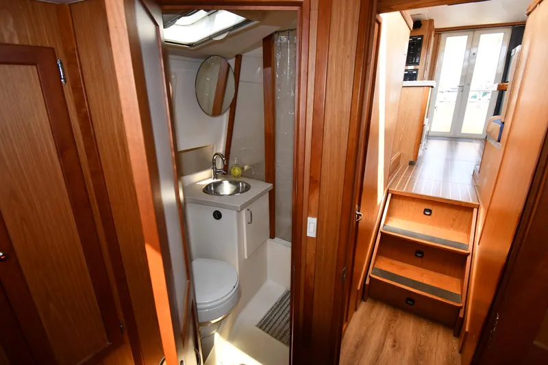 Slide: The Image of Interior of 2006 Mainship 40 Trawler, featuring a compact bathroom and wooden stairs. - 44
