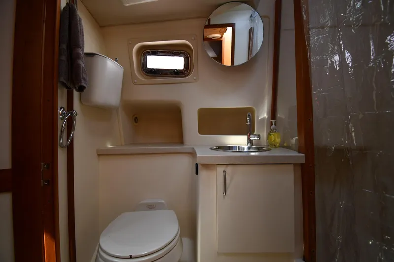 Slide: The Image of 2006 Mainship 40 Trawler bathroom with sink, toilet, and porthole window. - 47