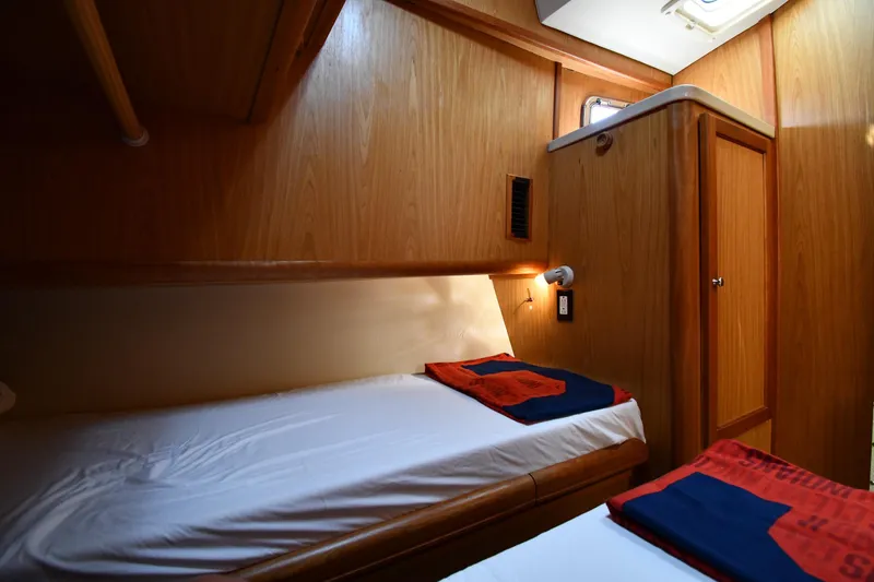 Slide: The Image of Cozy cabin interior of 2006 Mainship 40 Trawler with wooden paneling and twin beds. - 51