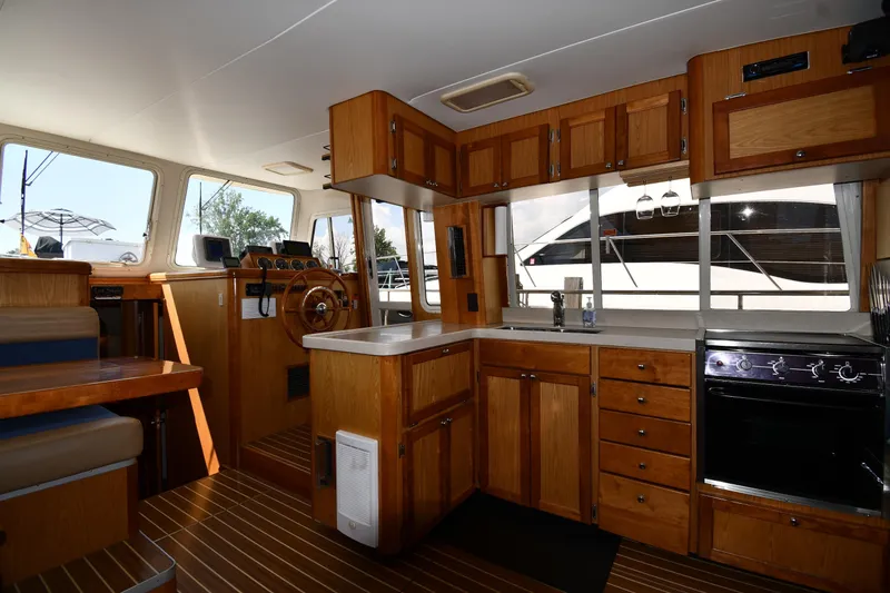 Slide: The Image of Interior of 2006 Mainship 40 Trawler with wooden cabinetry and modern kitchen amenities. - 52