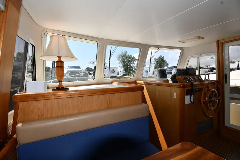 Slide: The Image of 2006 Mainship 40 Trawler interior with helm, seating, and lamp. - 56
