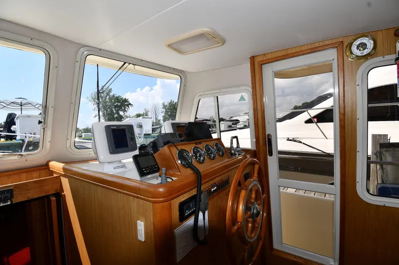 Slide: The Image of Interior helm of 2006 Mainship 40 Trawler with navigation equipment and wooden steering wheel. - 57