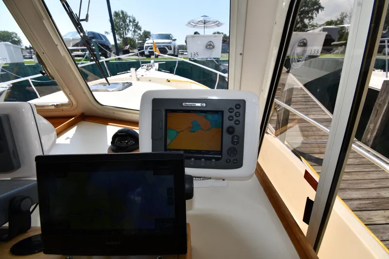 Slide: The Image of 2006 Mainship 40 Trawler helm with navigation equipment and dock view. - 59