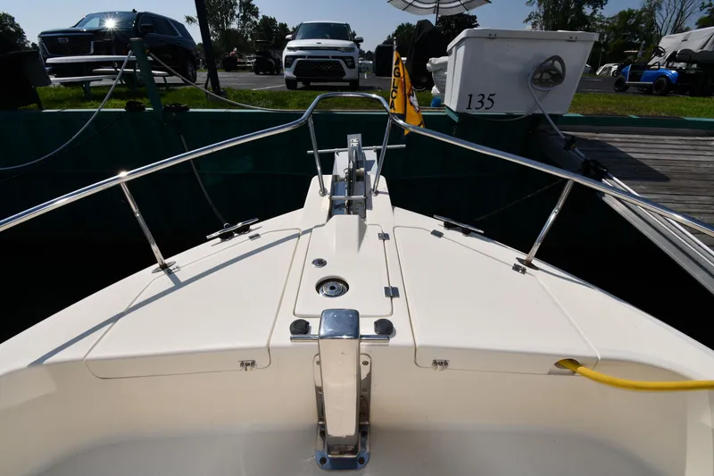 Slide: The Image of 2006 Mainship 40 Trawler bow view at dock with parked vehicles nearby. - 6