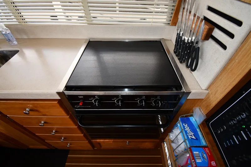 Slide: The Image of 2006 Mainship 40 Trawler kitchen with stove, countertop, and knife set. - 63