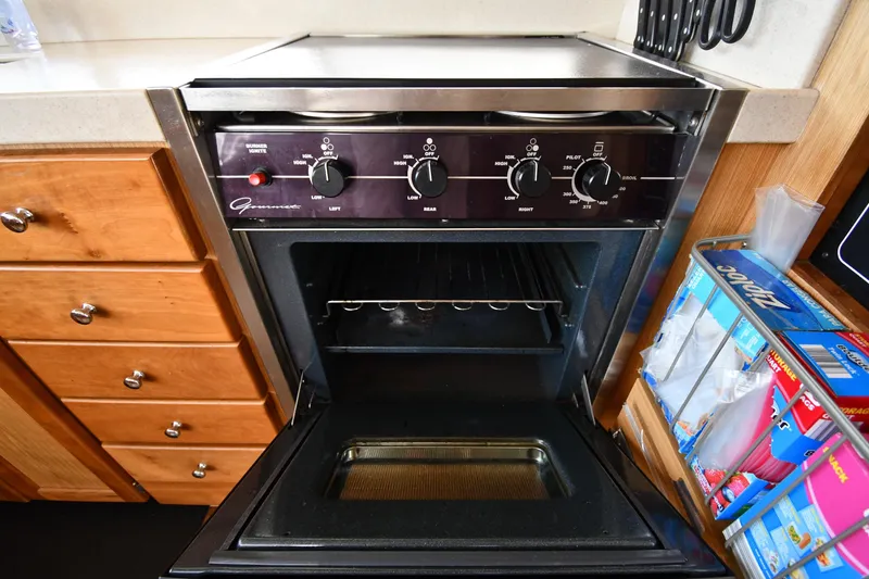 Slide: The Image of Galley oven in 2006 Mainship 40 Trawler, featuring control knobs and storage drawers. - 65