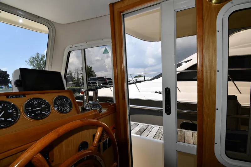 Slide: The Image of Interior view of 2006 Mainship 40 Trawler helm with wooden steering wheel and gauges. - 70