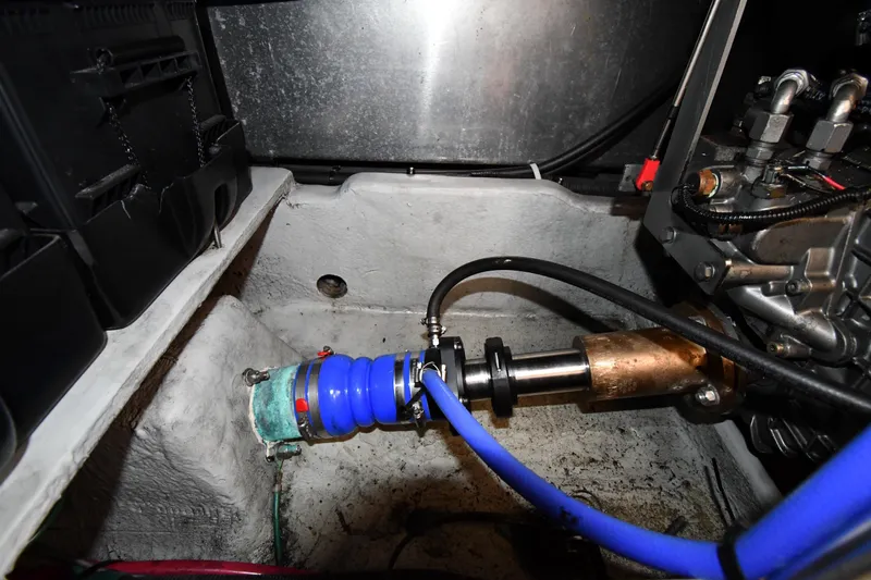 Slide: The Image of Engine compartment of a 2006 Mainship 40 Trawler, featuring hoses and mechanical components. - 78