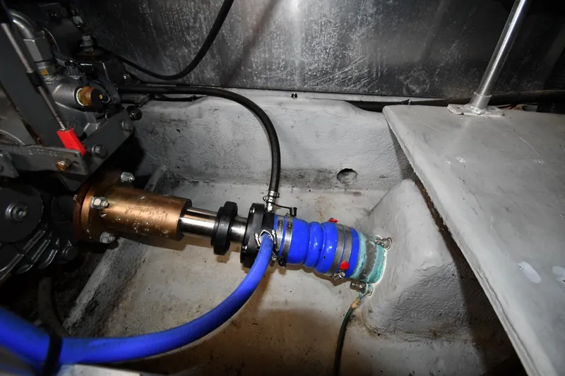 Slide: The Image of Engine compartment of a 2006 Mainship 40 Trawler with visible components and blue hose. - 79