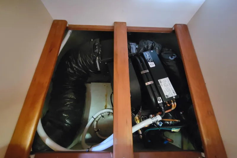 Slide: The Image of Engine compartment of a 2006 Mainship 40 Trawler with visible components and hoses. - 98