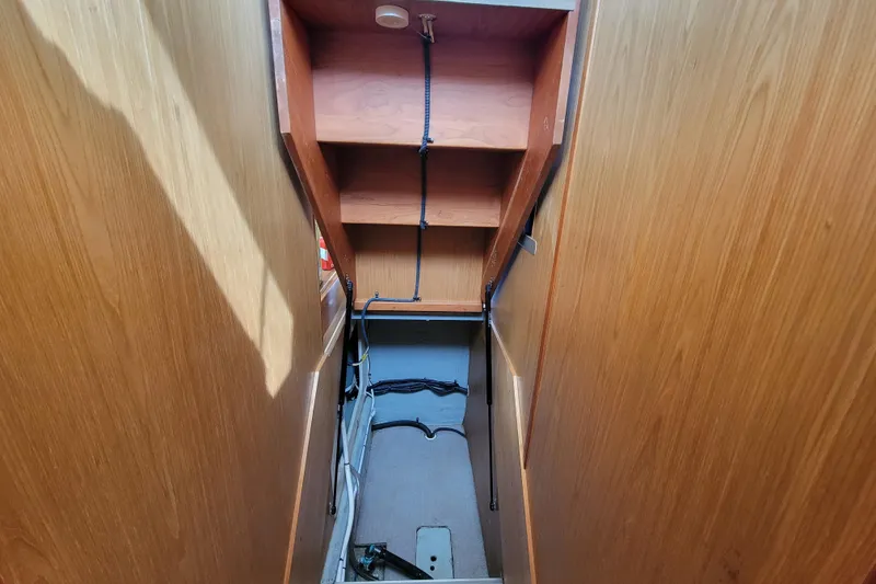 Slide: The Image of 2006 Mainship 40 Trawler interior with wooden walls and storage shelves. - 99