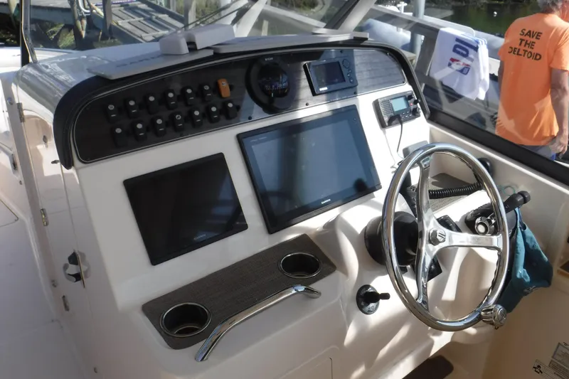 Slide: The Image of Helm of 2016 Grady White 355 Freedom boat with steering wheel and navigation screens. - 9