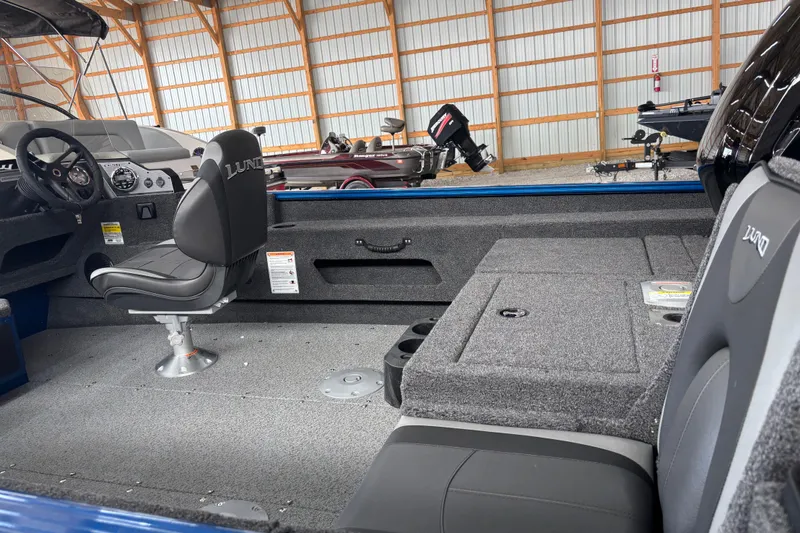 Slide: The Image of 2026 Lund 1775 Adventure SS boat with powerful outboard motor in a storage facility. - 3