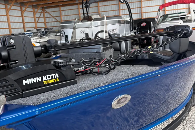 Slide: The Image of 2026 Lund 1775 Adventure SS boat interior with seating and steering wheel in a storage facility. - 4