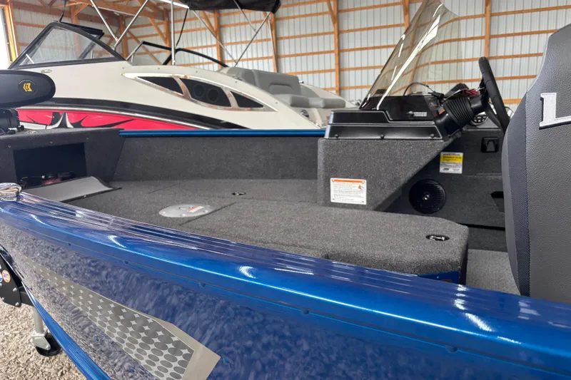 Slide: The Image of 2026 Lund 1775 Adventure SS boat on trailer, blue hull, parked on gravel. - 6