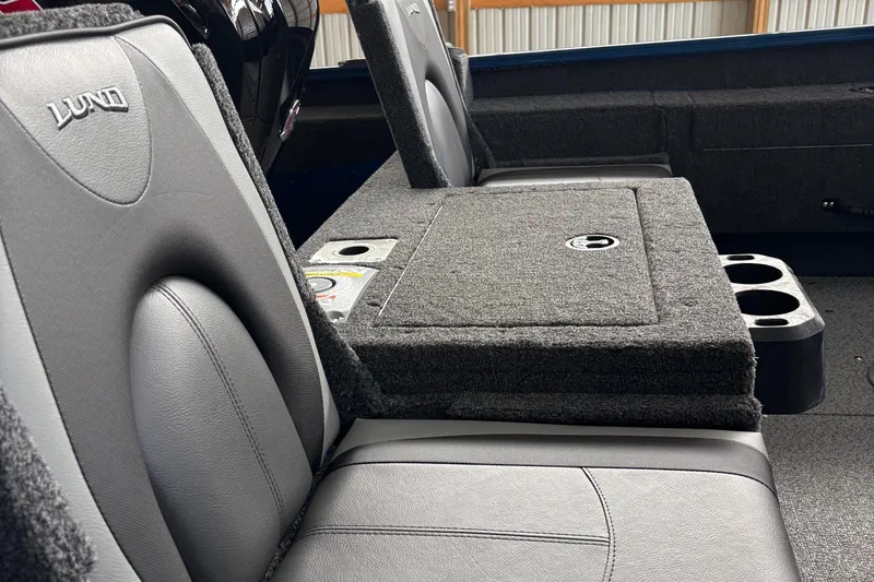 Slide: The Image of 2026 Lund 1775 Adventure SS boat interior with steering console and seating in a storage facility. - 7