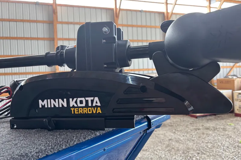 Slide: The Image of 2026 Lund 1775 Adventure SS boat interior with steering wheel and seating in a wooden shed. - 9