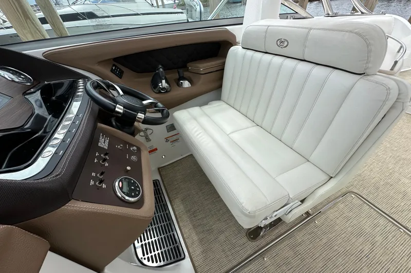 Slide: The Image of 2015 Cobalt 336 boat interior with white leather seating and modern dashboard controls. - 14