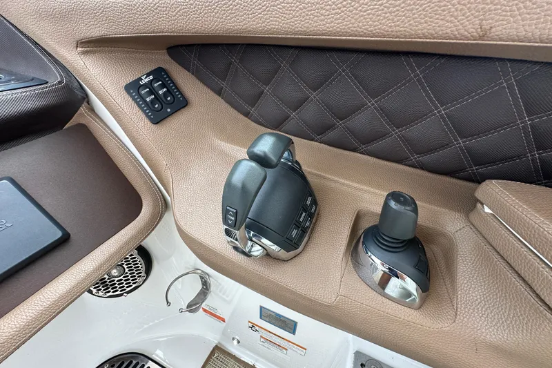 Slide: The Image of 2015 Cobalt 336 boat control panel with joystick and throttle, featuring brown leather accents. - 16