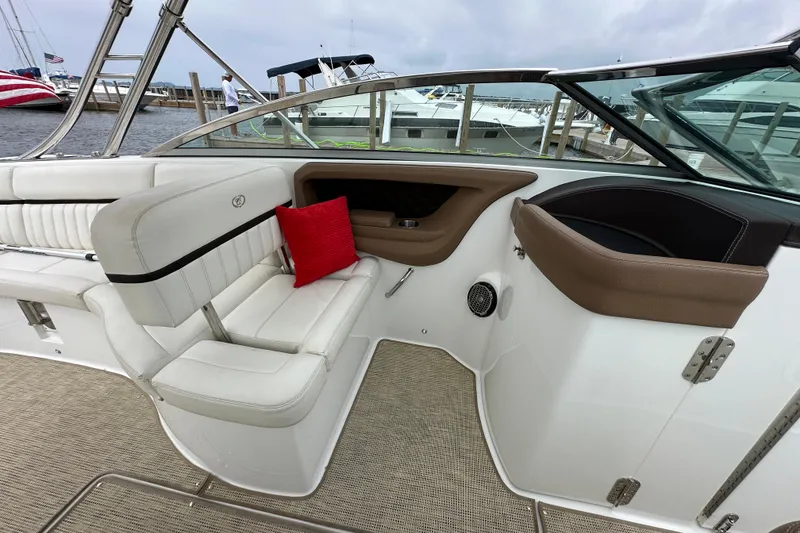 Slide: The Image of 2015 Cobalt 336 boat interior with white seating and red cushion at dock. - 17