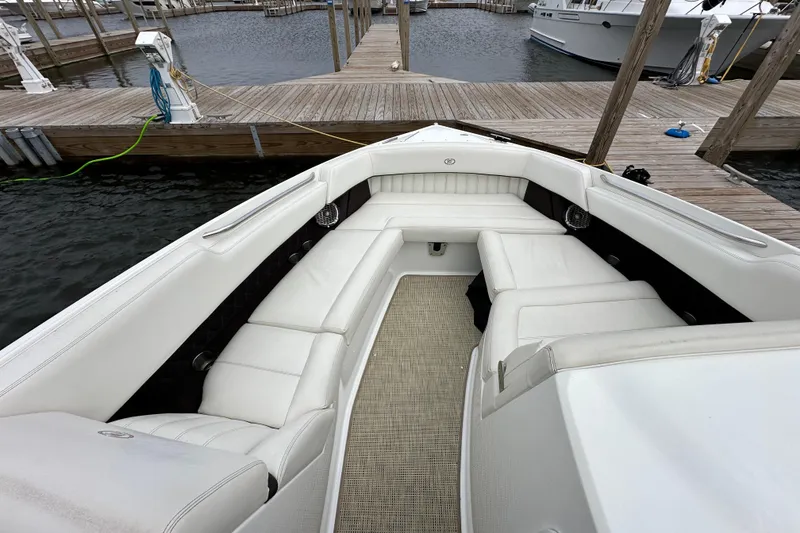 Slide: The Image of 2015 Cobalt 336 boat with white seating, docked at a marina. - 19